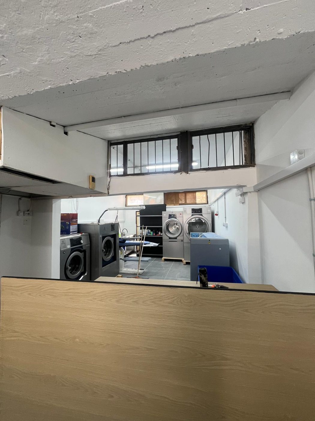 עמדת העבודה במכבסה עם פריטים מוכנים לגיהוץ בקיטור
