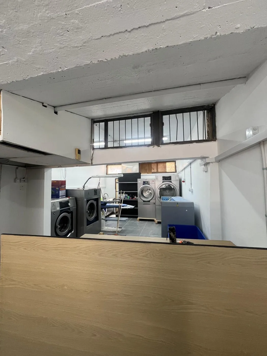 עמדת העבודה במכבסה עם פריטים מוכנים לגיהוץ בקיטור